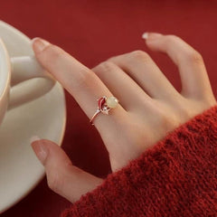 Koi Jade Ring – worn on finger with red knit sweater, holding white teacup, red background, 18K gold feng shui luck ring