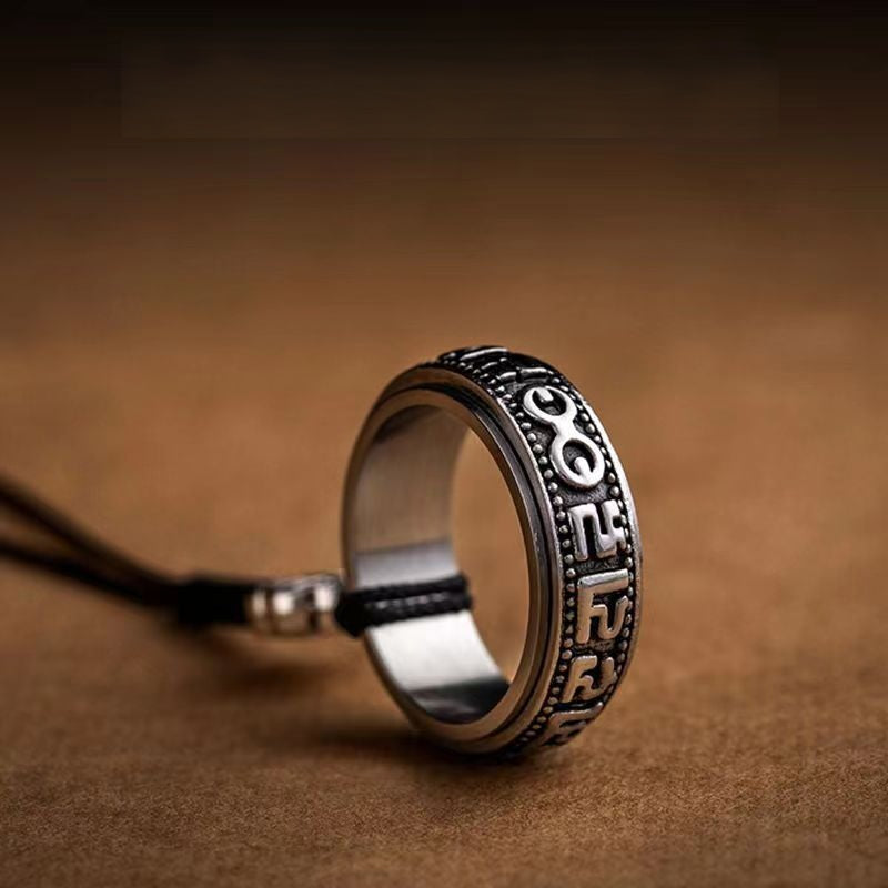 Mantra Phone Ring – upright silver ring showing six-word mantra engravings on brown textured surface