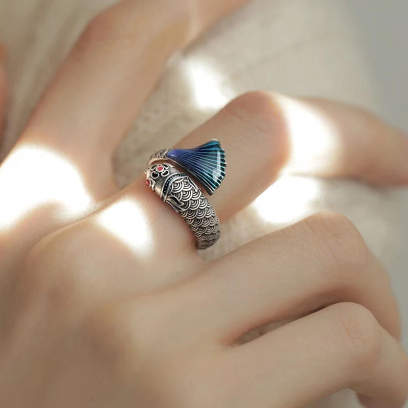 Enamel Carp Ring – worn on finger in gentle natural sunlight with soft beige fabric background, silver carp ring