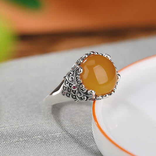 Vintage Silver Honey Amber Ring – Amber ring leaning on white ceramic dish with orange rim, energy jewelry
