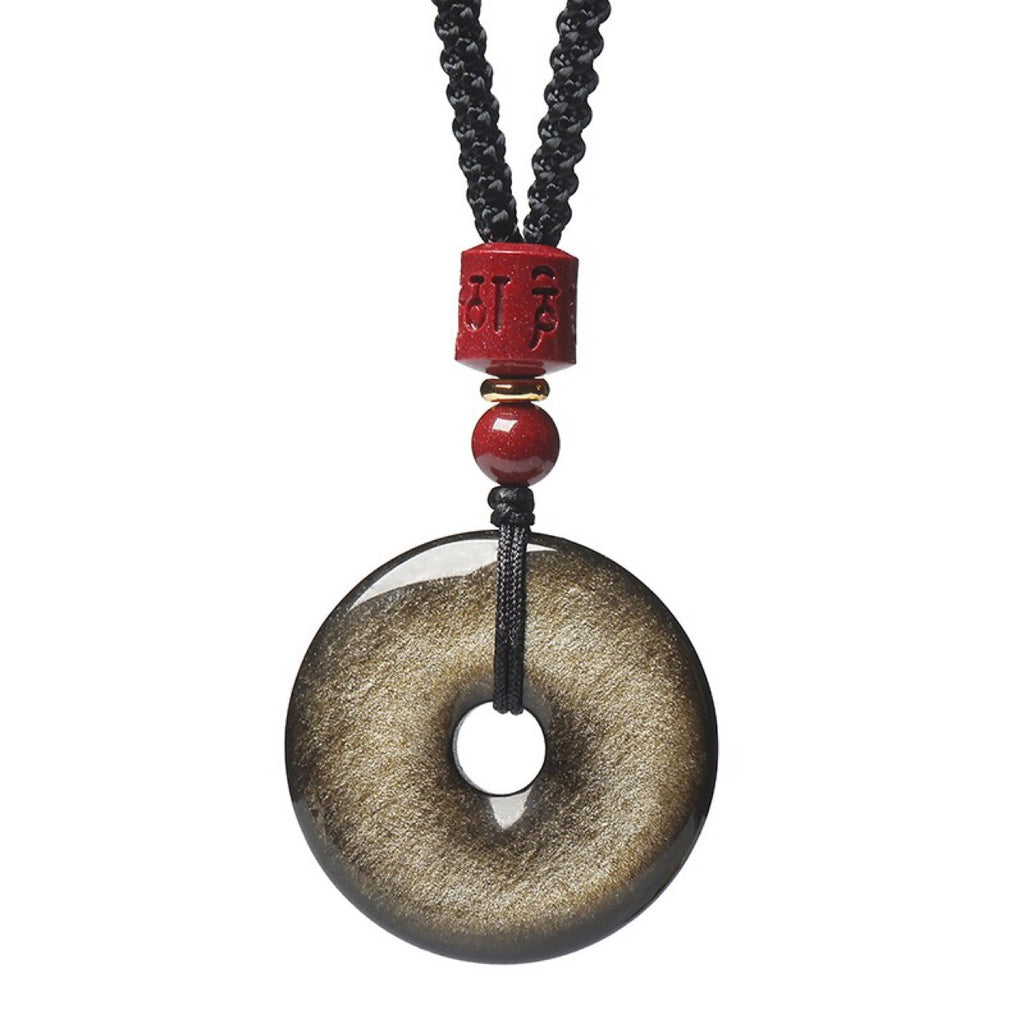 Gold Obsidian Pendant – Close-up of gold sheen obsidian peace button with red mantra bead on white, crystal pendant