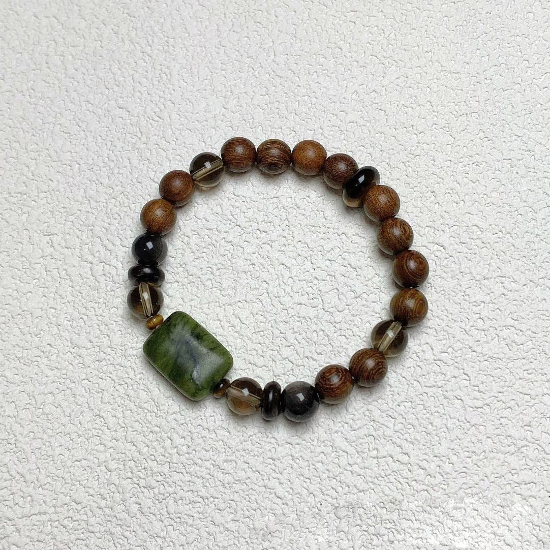 Sandalwood Wushi Bracelet – Overhead view of sandalwood bracelet with jade plaque and black obsidian beads