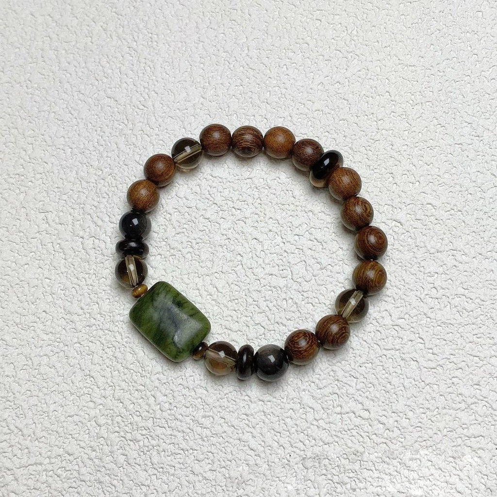 Sandalwood Wushi Bracelet – Overhead view of sandalwood bracelet with jade plaque and black obsidian beads
