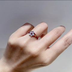 Red String Flower Ring – worn on finger with natural daylight, red thread band, white flower center, gold feng shui lucky charm