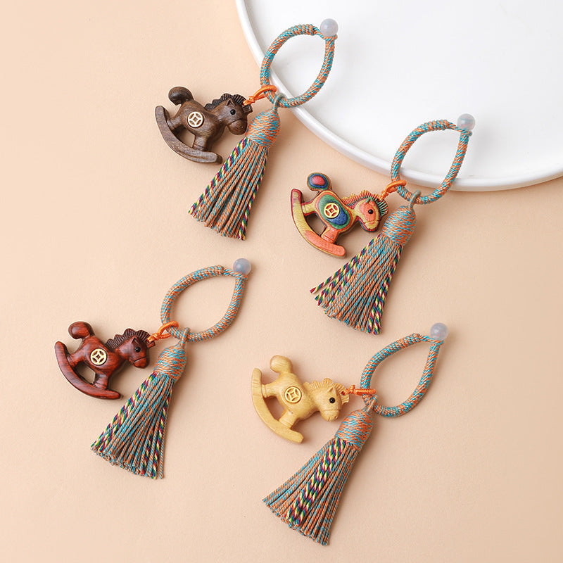 Rainbow Wooden Horse Keychain – four color variants displayed together with braided rope tassels