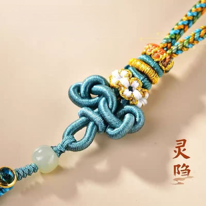 蓝绿色文昌结特写，展示精致花结和白玉珠工艺