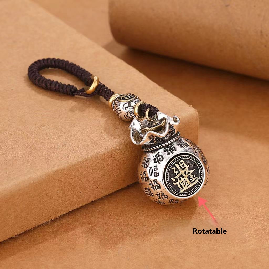 Rotating coin money pouch keychain demonstrating rotatable feature with arrow indicator on brown background