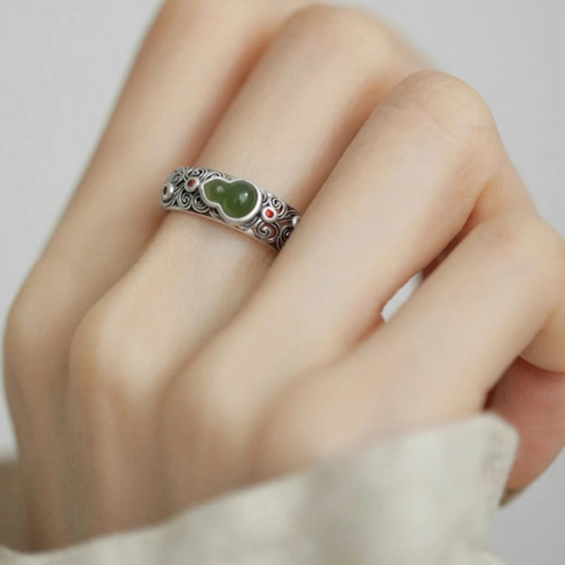 Jade Gourd Ring – adjustable silver ring with green jade double-gourd center, finger model with white background, wellness accessory