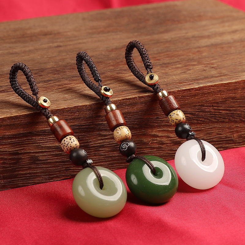 Three color variations of natural agate ping an kou keychains displayed together