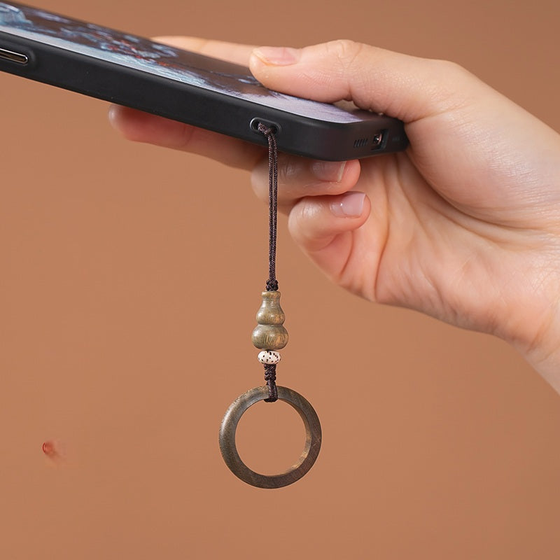 Sandalwood Phone Grip – Hand holding phone with green sandalwood ring grip on warm brown background, in-use lifestyle shot