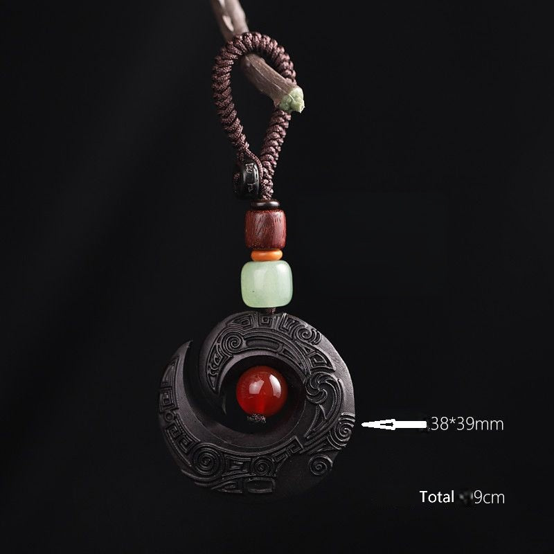 Feng Shui ebony wood protection keychain with antique incense burner on dark elegant background