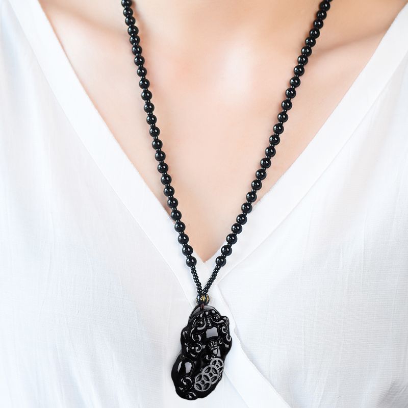 Obsidian Pixiu Necklace – Model wearing black obsidian bead necklace with pixiu pendant, white V-neck top