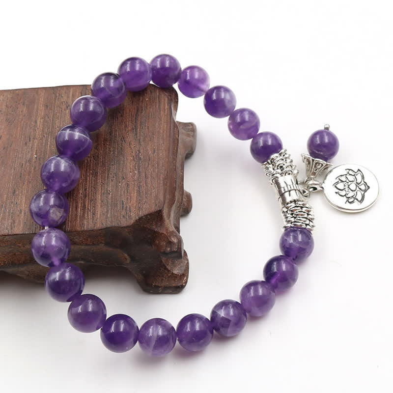 Amethyst Lotus Bracelet - draped on dark wood, oxidized lotus disc and stone beads, zen