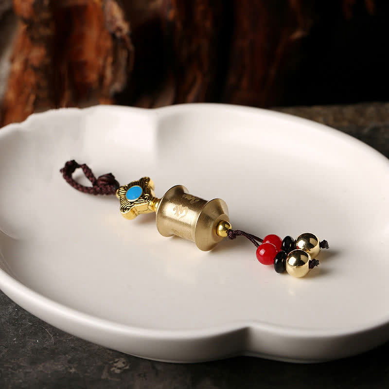 Feng Shui Yin Yang Bagua Keychain - Brass prayer wheel drum on white ceramic dish, feng shui pendant