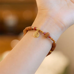 Bodhi Seed Bracelet – Carved focal bead and gold fortune pendant on wrist, natural stone bracelet