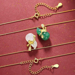 Cyan Jade Gourd Pendant Necklace - two gourd variants with ribbon bow CZ accents and extender chains, flat lay