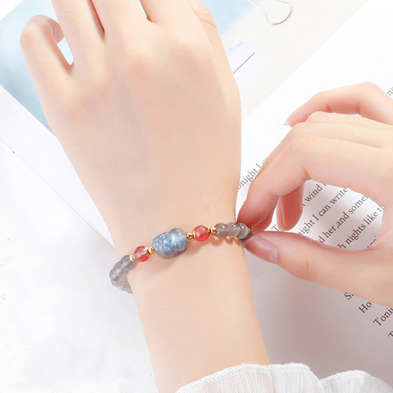 Moonstone PiXiu Bracelet – Bracelet worn on wrist over book page, everyday healing jewelry