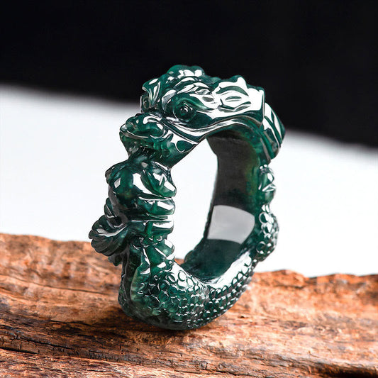 Cyan Jade Dragon Ring on dark wood, carved dragon head, backlit teal translucency, success talisman