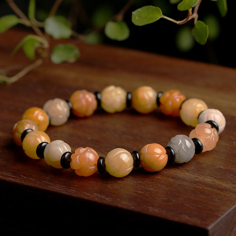 Golden Silk Jade Lotus Bracelet – Carved lotus beads in peach amber tones with black spacers on wood, lotus jade