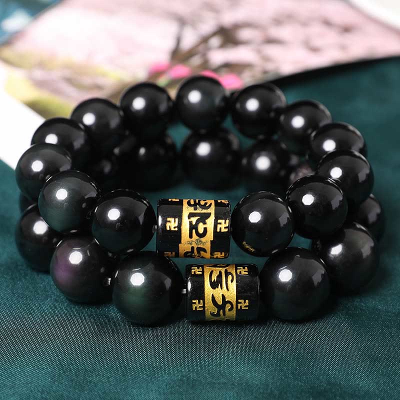 Rainbow Obsidian Bracelet – Two stacked black bead bracelets with gold mantra beads on dark green silk, prayer beads