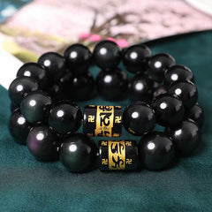Rainbow Obsidian Bracelet – Two stacked black bead bracelets with gold mantra beads on dark green silk, prayer beads