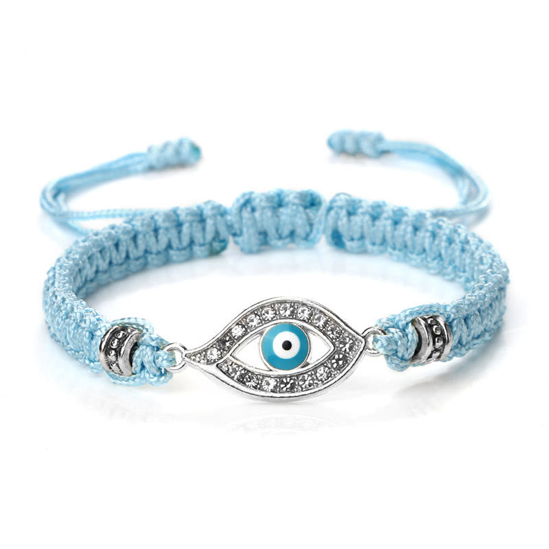 Light blue cord evil eye bracelet with silver crystal pave evil eye charm on white bg