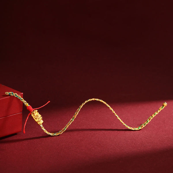 Year of the Dragon Braided Bracelet - Side view on red box with ornate gold charm, Auspicious design