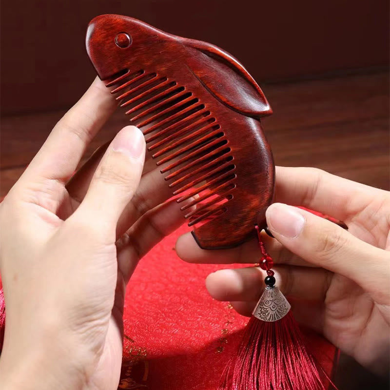 Hands holding bunny comb over red fabric showing detailed craftsmanship