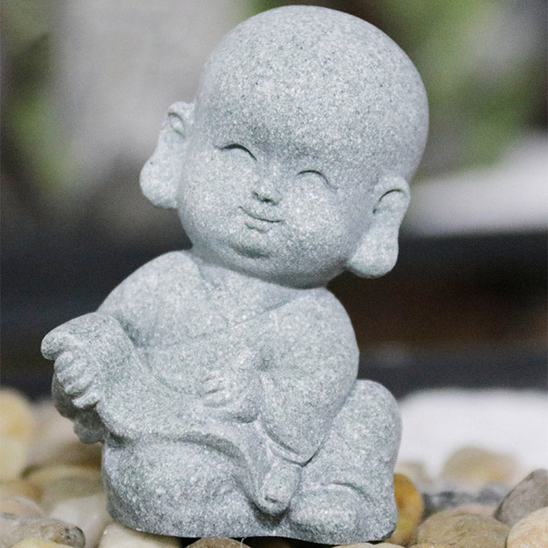 Meditation Monk Statue - Seated baby monk in meditation pose on colorful pebble stones