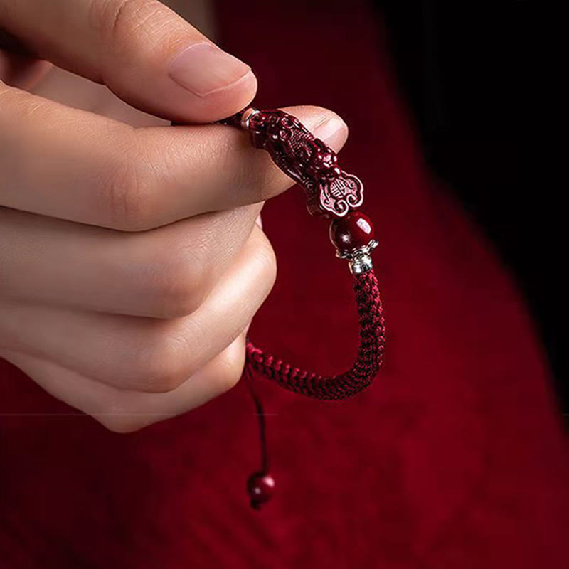 Handcrafted PiXiu Cinnabar Wealth Luck Braided Bracelet – hand holding adjustable bracelet with tassel, close view