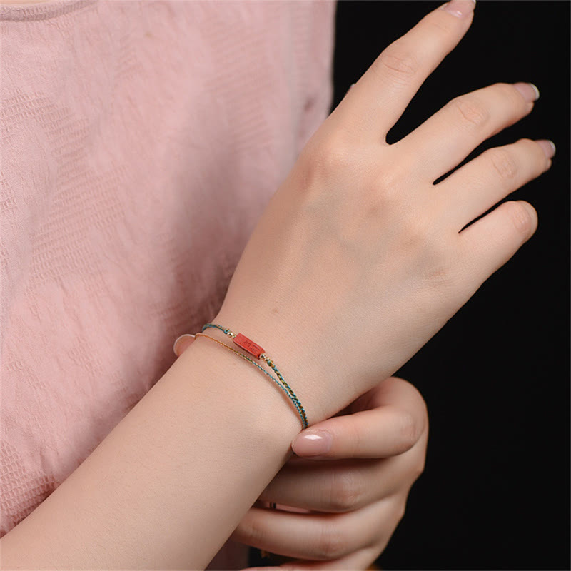 Cinnabar Bracelet - Adjustable cord bracelet worn on wrist with gold chain, wrist jewelry