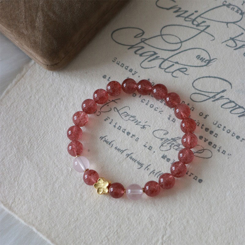 Strawberry Quartz Peach Blossom PiXiu Bracelet – pink bead bracelet on vintage calligraphy paper, lifestyle flat lay