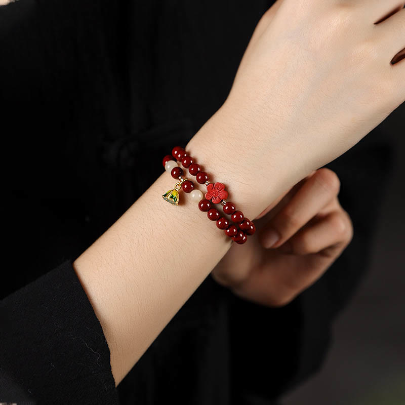 Cinnabar Lotus Bracelet – double wrap worn on wrist with lotus charm, red beaded bracelet