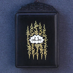 Ebony Wood Lotus Pendant – Close-up lotus and gold script on black stone, Zen