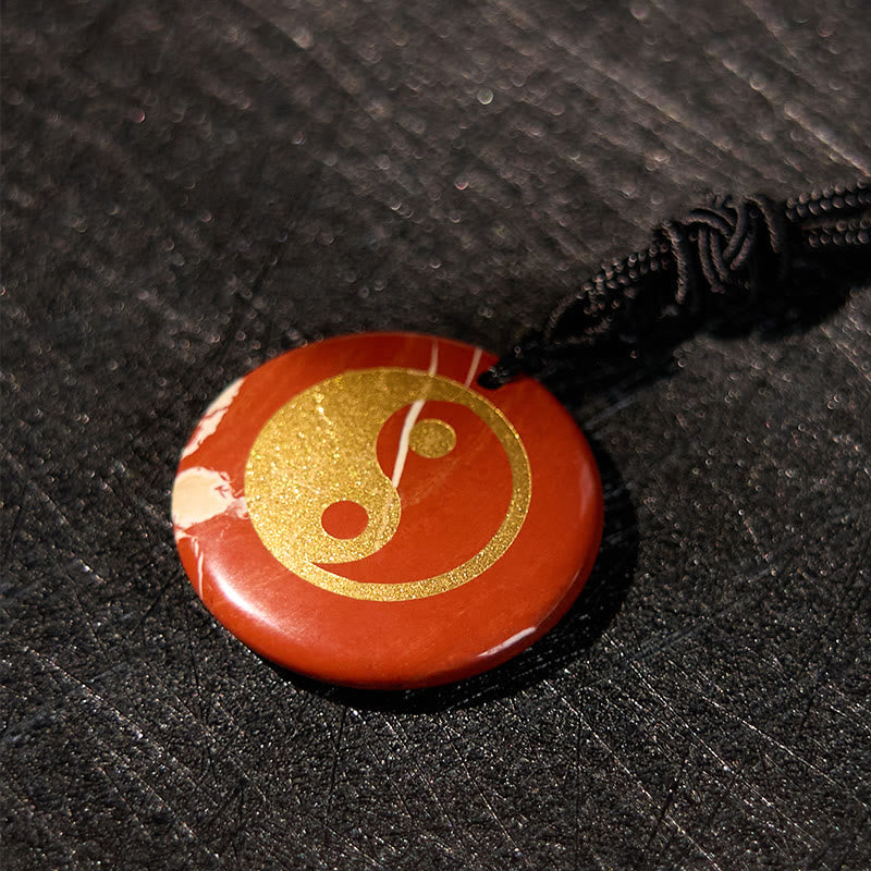 Yin Yang Crystal Necklace – Red jasper round pendant with gold yin-yang inlay, natural white marbling on polished stone, blac