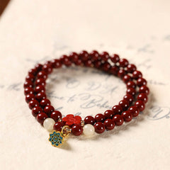 Cinnabar Lotus Bracelet – double strand on vintage paper with enamel pendant, beaded bracelet