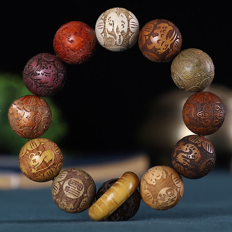 Chinese Zodiac Wood Bracelet – 12 multi-wood beads with zodiac engravings, cylindrical guru bead, black backdrop