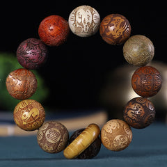 Chinese Zodiac Wood Bracelet – 12 multi-wood beads with zodiac engravings, cylindrical guru bead, black backdrop