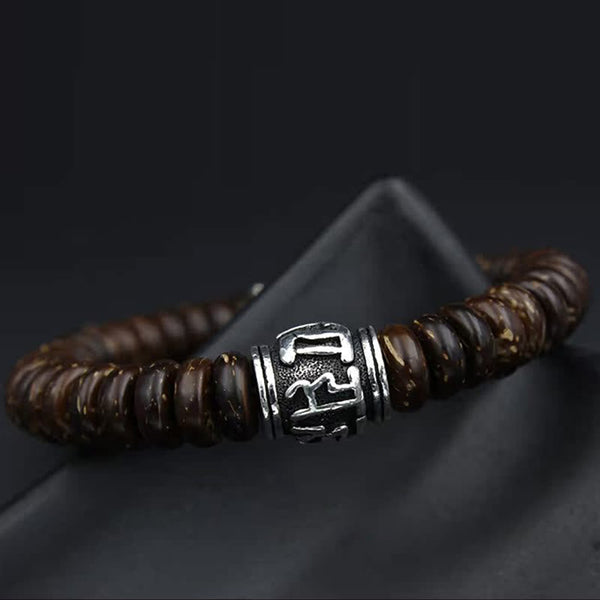 Om Mani Padme Hum Coconut Shell Bracelet – low angle on black stand, engraved silver bead