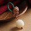 Bodhi Seed Peach Wood Lotus Keychain – Carved lotus flower pendant with wooden seed pods on green braided cord, bodhi seed keychain