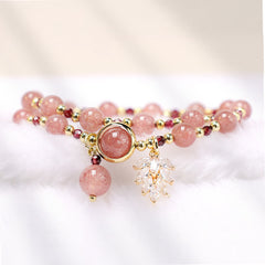 Double-wrap strawberry quartz bracelet with soft pink beads deep red garnet spacers gold findings crystal leaf cluster charm on white fluffy cloud background