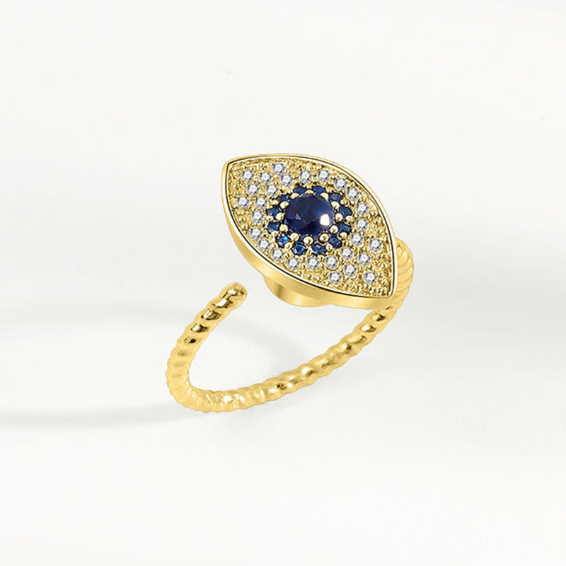 Evil Eye Rotatable Ring – Gold evil eye ring with sapphire blue stone, pave halo, on white background