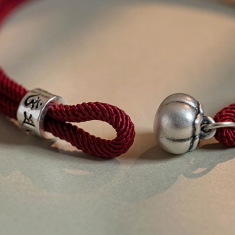 Om Mani Padme Hum Bracelet - Burgundy cord with antiqued silver bell and mantra cylinder on soft background