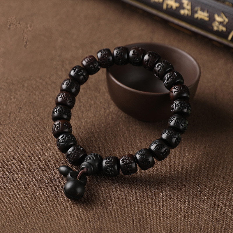 Lightning Strike Wood Bracelet – Black wood bracelet with carved beads and gourd charm on fabric, protection amulet