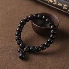 Lightning Strike Wood Bracelet – Black wood bracelet with carved beads and gourd charm on fabric, protection amulet