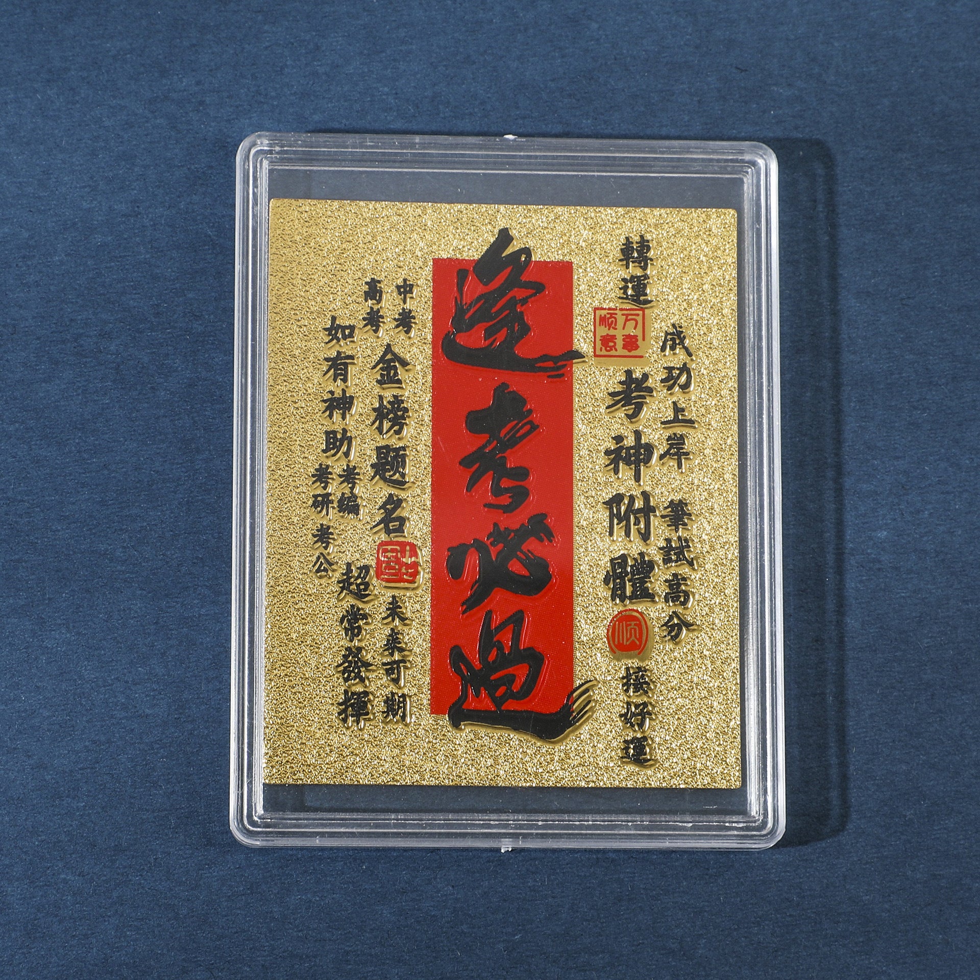 Gold Exam Success fortune sticker in clear display case on blue background