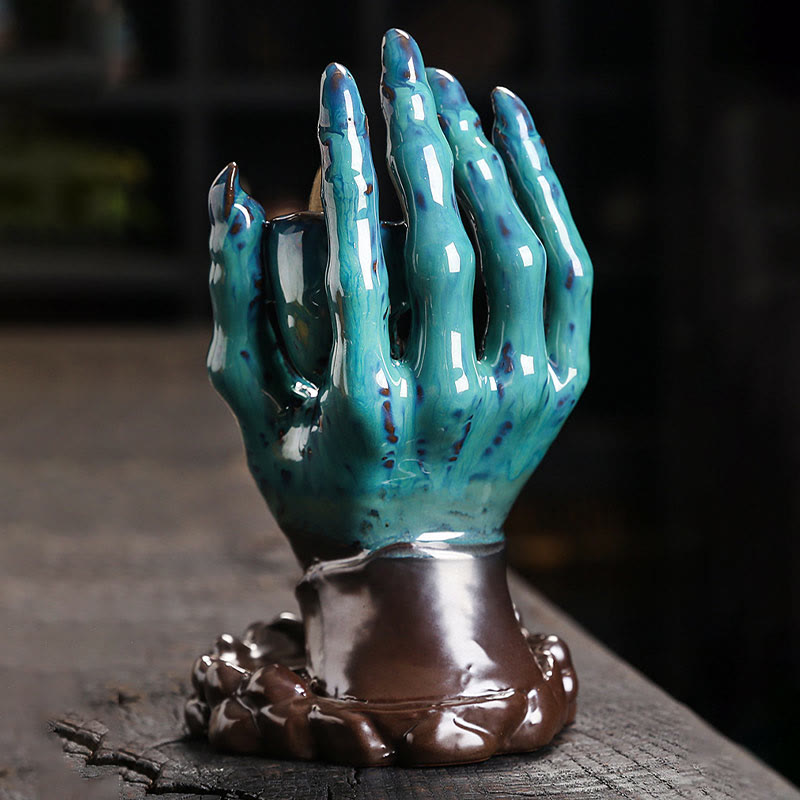 Ceramic Ghost Hand Skull Incense Burner – Teal glazed hand without smoke, glossy ceramic finish, moody dark background