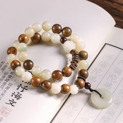 Bodhi Seed Sandalwood Lotus Bracelet - jade and wood beads with peace buckle on scripture page, serene