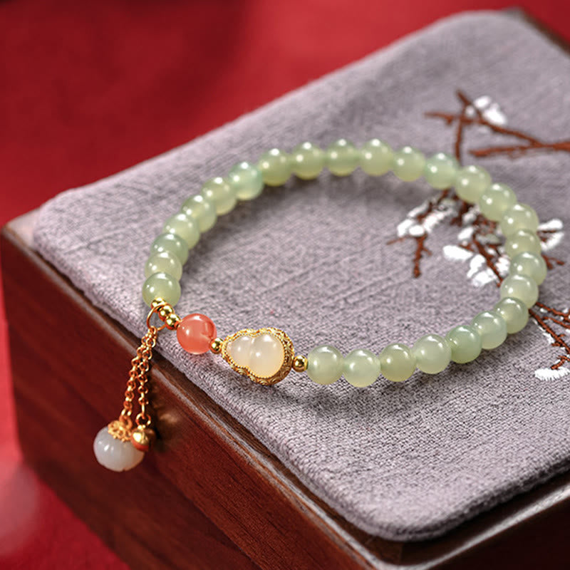 Hetian Jade Gourd Lotus Bracelet in velvet tray with dried flowers on rosewood box, warm heritage styling