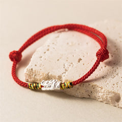 Sterling Silver Dragon Red Rope Bracelet - silver textured bead on red braided cord resting on stone, Style